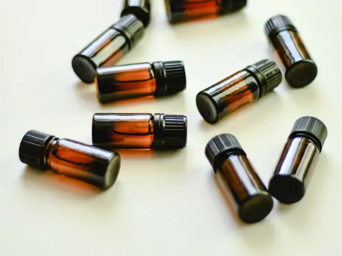 Small amber vials of aroma materials laid out on a white surface