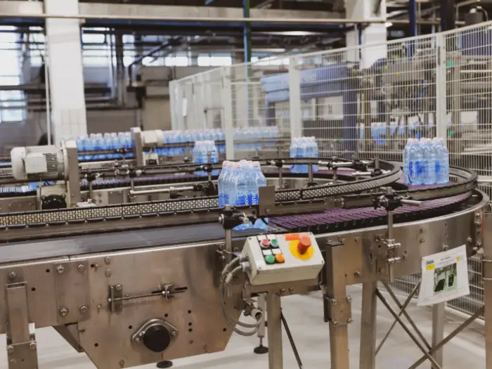 Filled bottles travelling along a conveyor in a packing hall