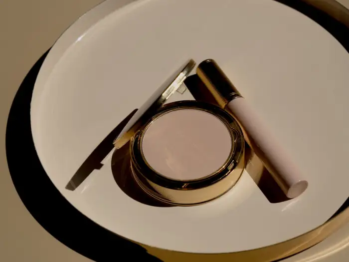 A finished compact and packaging components on a neutral surface