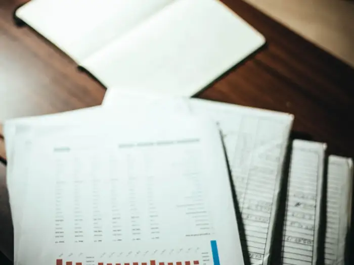 An overhead view of stacked documents and data sheets on a desk